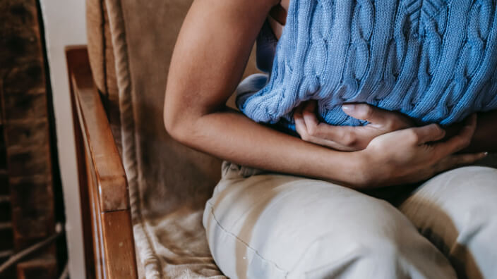 Frau mit Regelschmerzen zur Veranschaulichung des Beitrags zu Menstruationsurlaub in Unternehmen